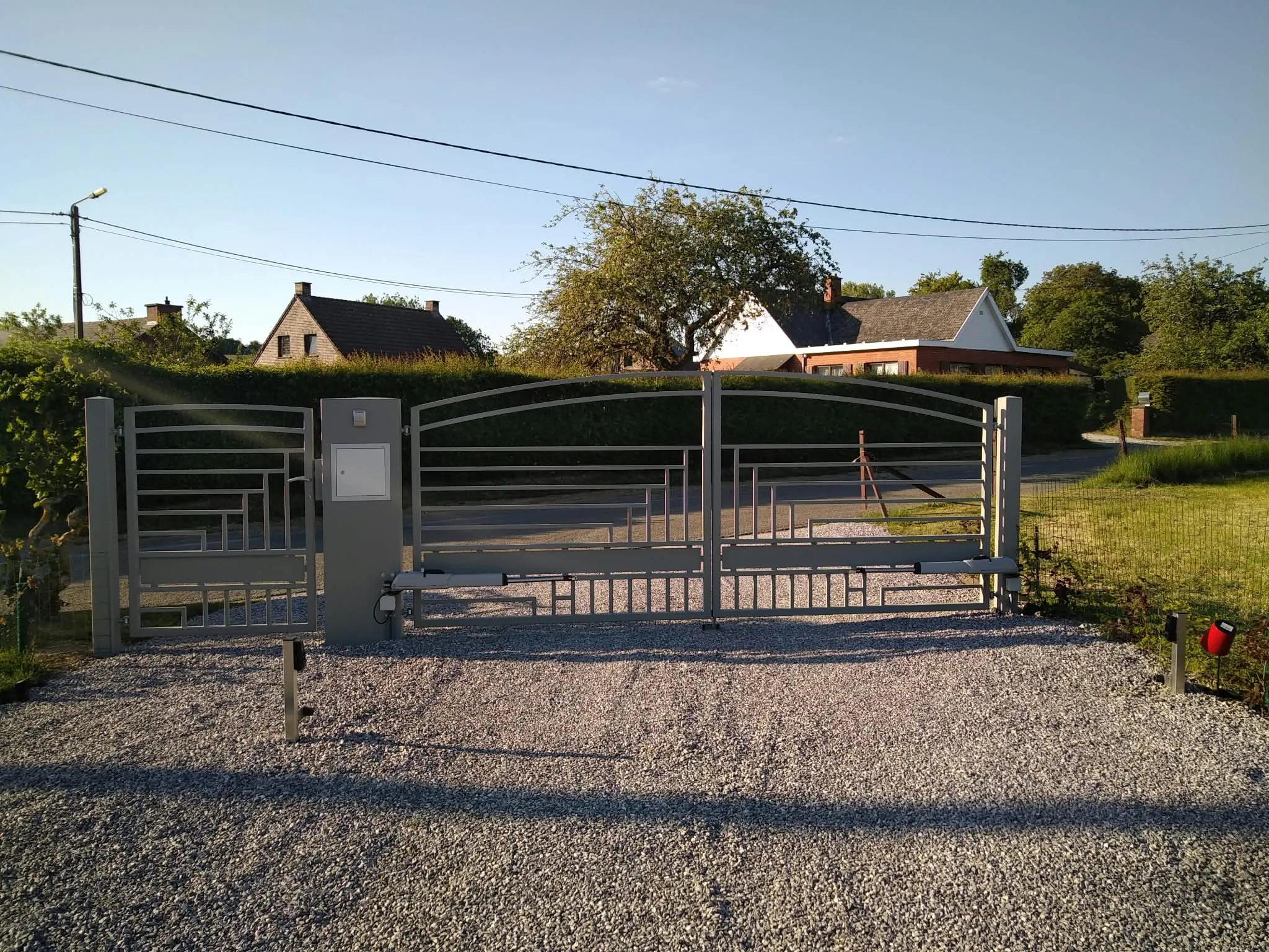 Portail battant contemporain gris avec portillon et bras de motorisation